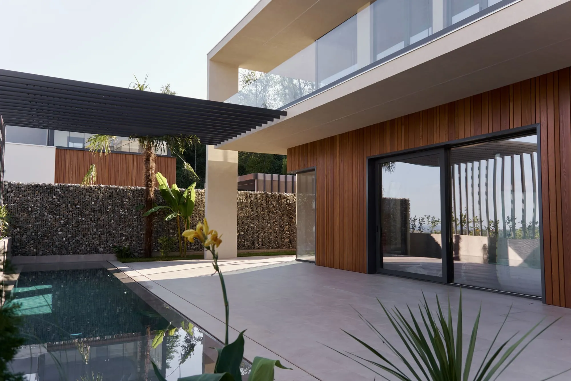 Villa O: wooden facade and pergola over the terrace